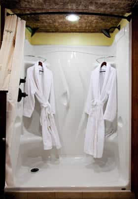 Princess Helena guest bath shower with curved curtain rod and two hanging white robes