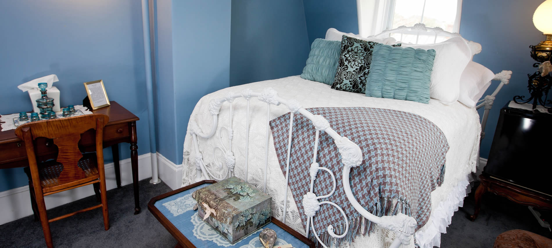 Princess Victoria guest room bed, blue walls, white bedding, blue pillows and writing desk