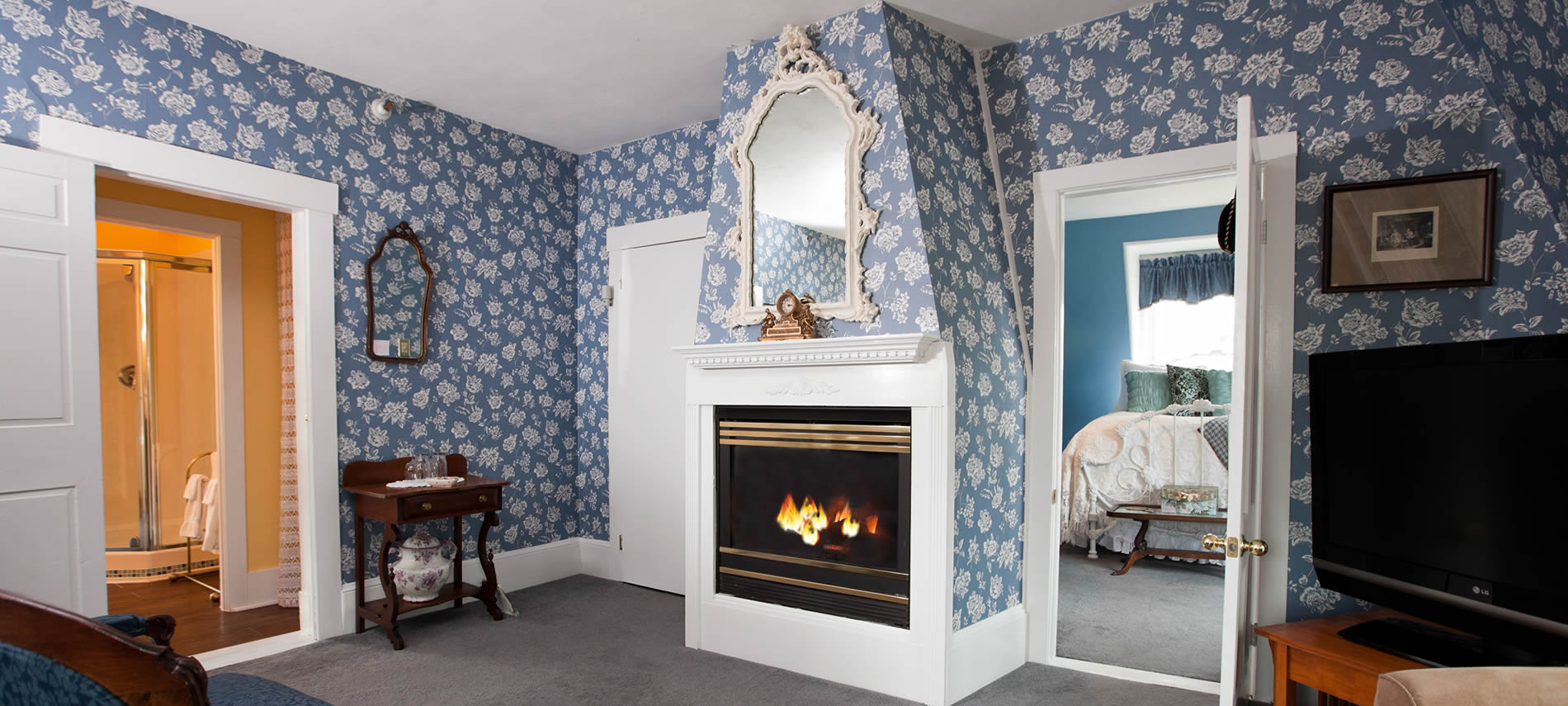 Princess Victoria guest room, blue and white wallpaper, white trim and doors, and fireplace